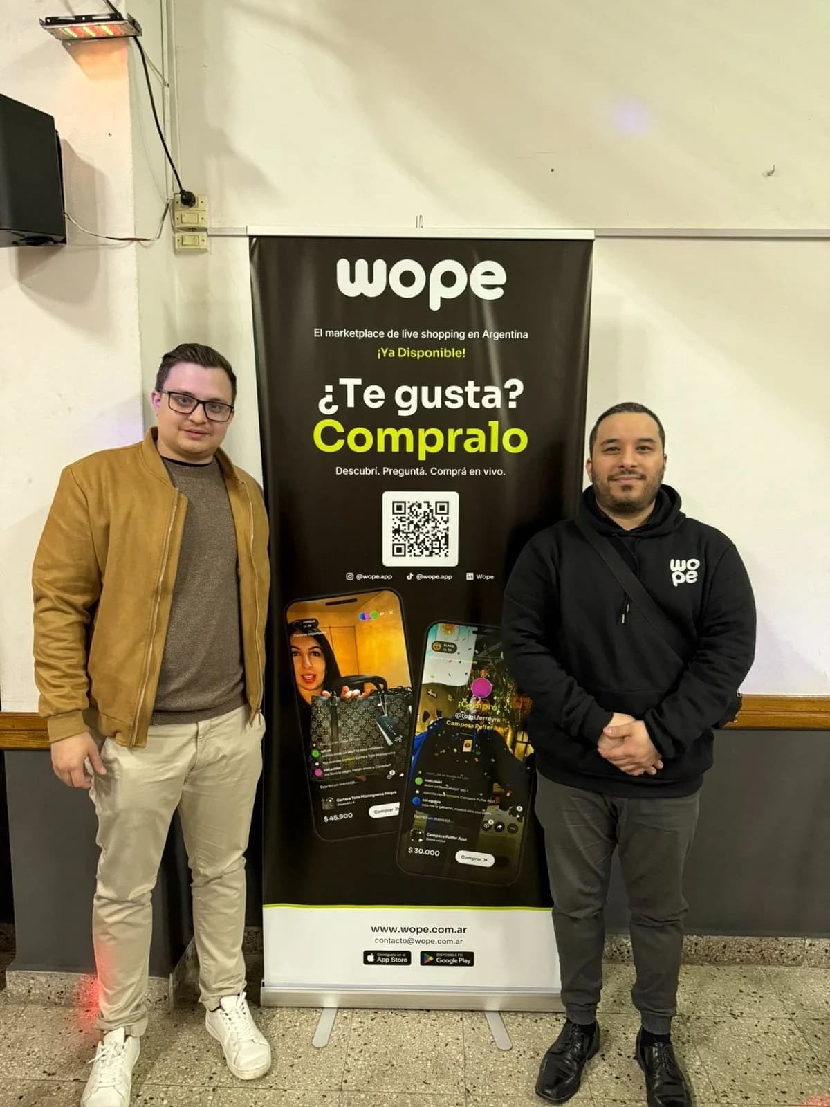 Alonso Díaz y Adrián Saladino, fundadores de Wope, junto a un banner de la app